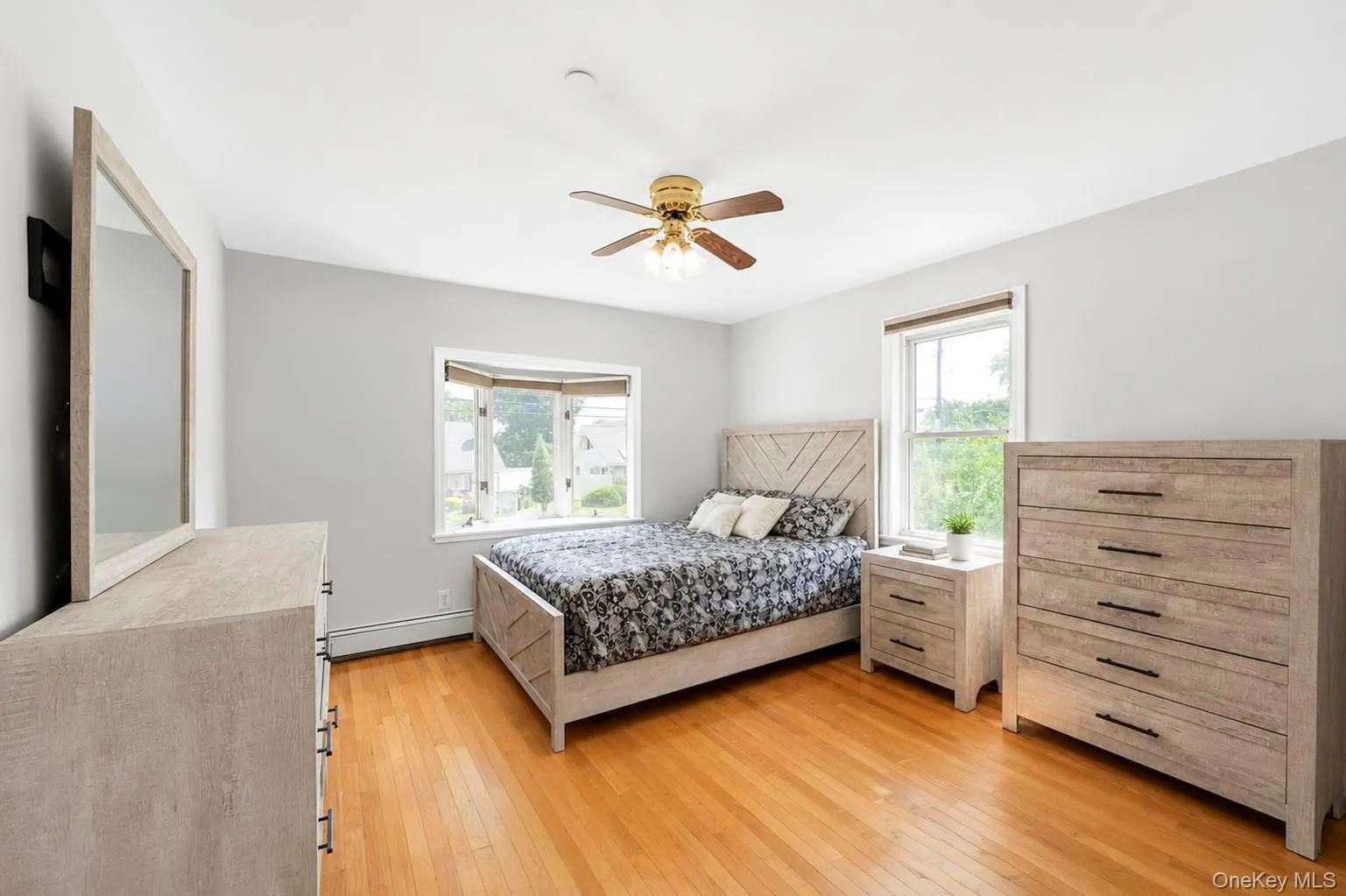 Hardwood flooring, bay window, ceiling fan, and light gray wall paint Hardwood flooring, bay window, ceiling fan, and light gray wall paint