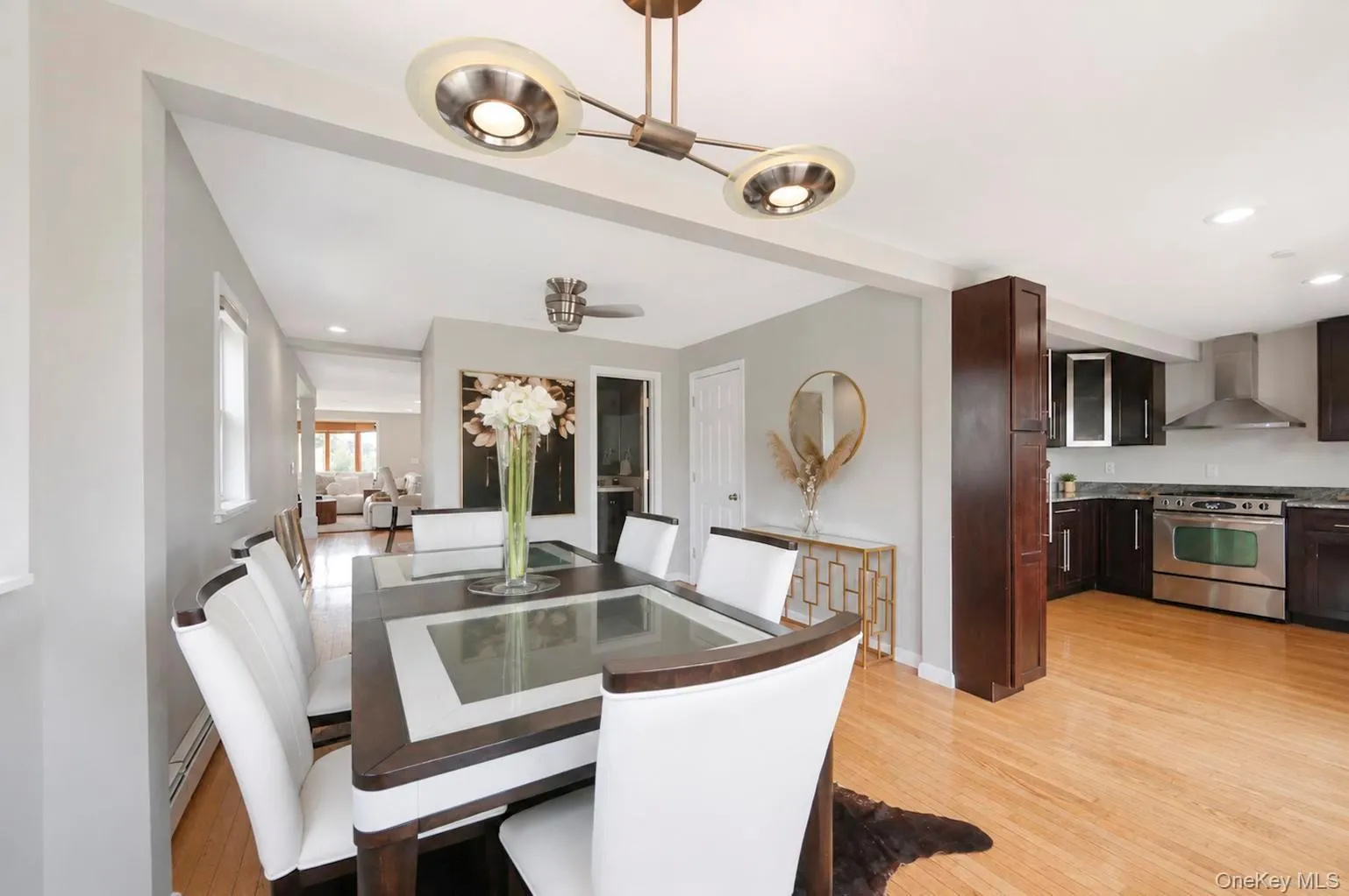 Hardwood flooring, recessed lighting, and a contemporary ceiling light fixture Hardwood flooring, recessed lighting, and a contemporary ceiling light fixture