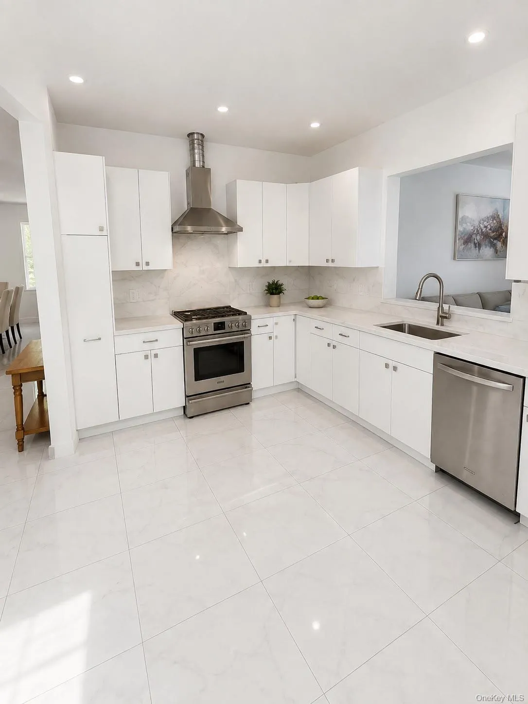Bright kitchen featuring white cabinetry, stainless steel appliances, stone countertops, and tile flooring Bright kitchen featuring white cabinetry, stainless steel appliances, stone countertops, and tile flooring