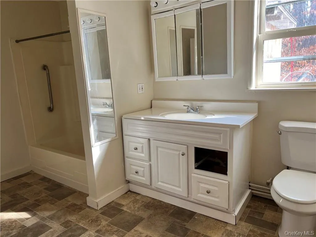 Full bathroom with vanity, toilet, and shower / bathtub combination Full bathroom with vanity, toilet, and shower / bathtub combination