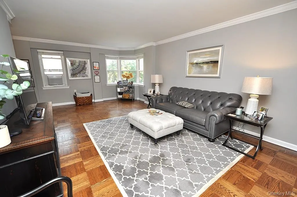 The large living room has refinished parquet floors, a bay window and opens to both the dining room and foyer. The living room is approx 21'-5' x 12'-6" . The large living room has refinished parquet floors, a bay window and opens to both the dining room and foyer. The living room is approx 21'-5' x 12'-6" .