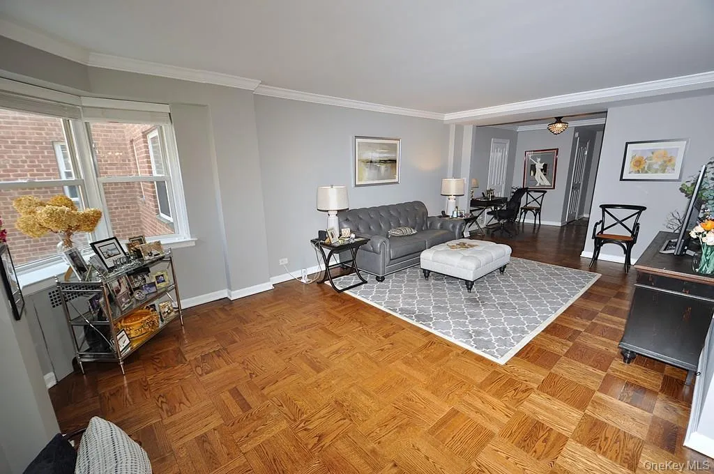 The large living room has refinished parquet floors, a bay window and opens to both the dining room and foyer. The living room is approx 21'-5' x 12'-6" . The large living room has refinished parquet floors, a bay window and opens to both the dining room and foyer. The living room is approx 21'-5' x 12'-6" .