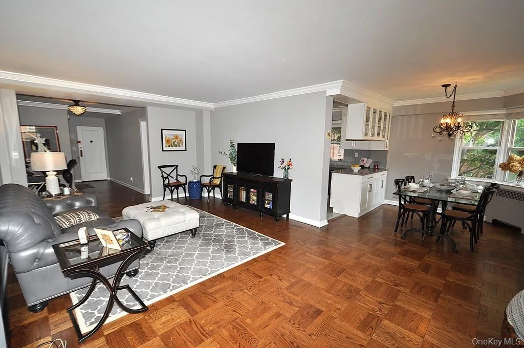 The large living room has refinished parquet floors, a bay window and opens to both the dining room and foyer. The living room is approx 21'-5' x 12'-6" . The large living room has refinished parquet floors, a bay window and opens to both the dining room and foyer. The living room is approx 21'-5' x 12'-6" .