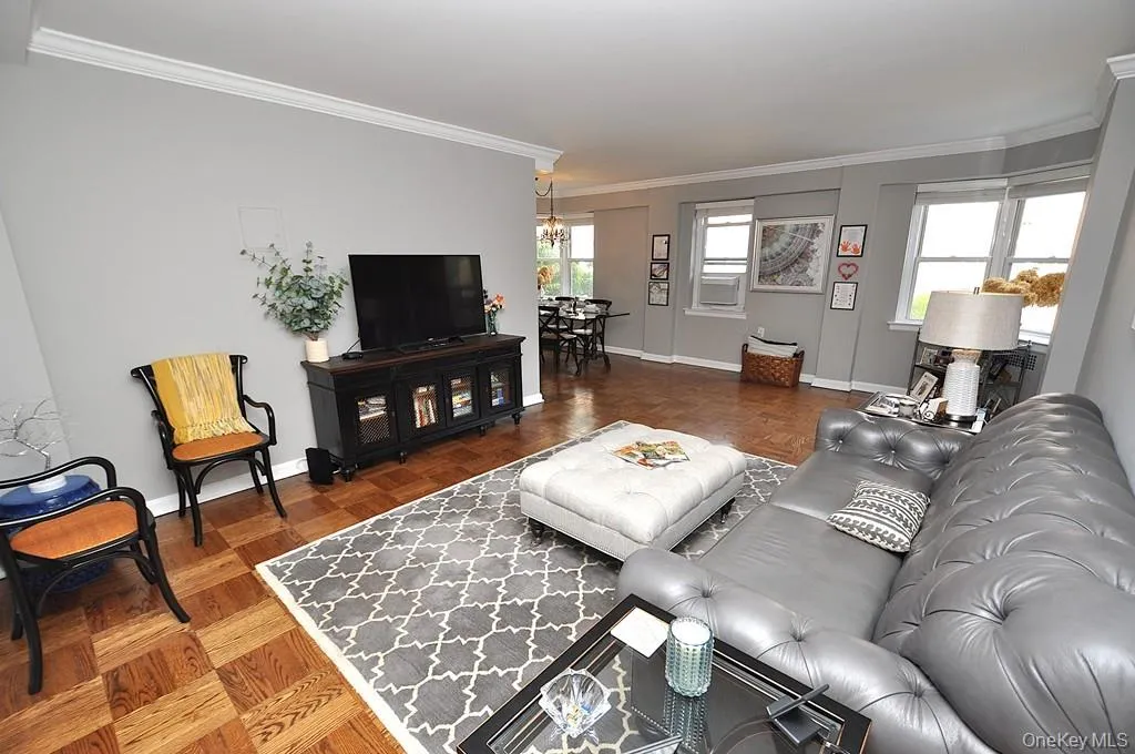 The large living room has refinished parquet floors, a bay window and opens to both the dining room and foyer. The living room is approx 21'-5' x 12'-6" . The large living room has refinished parquet floors, a bay window and opens to both the dining room and foyer. The living room is approx 21'-5' x 12'-6" .
