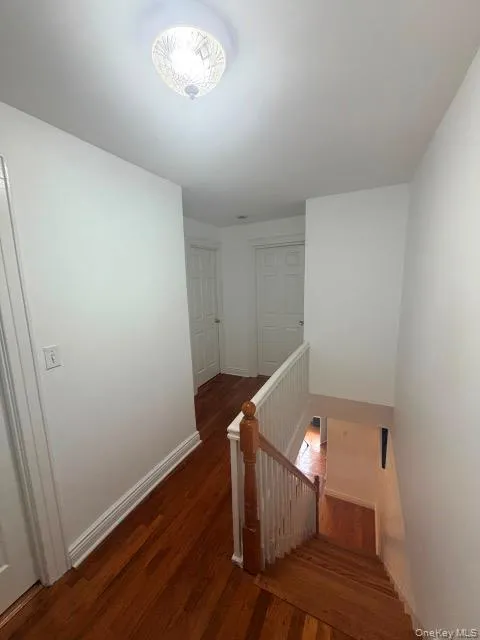 Hardwood flooring throughout, white painted walls, white ceiling, white stair railing, and a flush mount ceiling light fixture Hardwood flooring throughout, white painted walls, white ceiling, white stair railing, and a flush mount ceiling light fixture