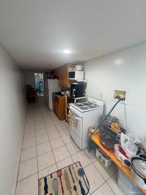 Tile flooring, recessed lighting, wood-finish cabinetry, and a gas range Tile flooring, recessed lighting, wood-finish cabinetry, and a gas range