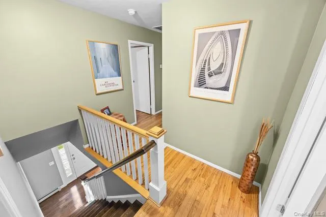 Second floor. Hardwood flooring, painted walls, white trim, wood handrail, spindle staircase Second floor. Hardwood flooring, painted walls, white trim, wood handrail, spindle staircase
