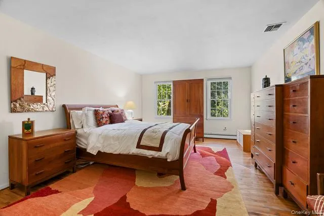 Hardwood flooring throughout, featuring multiple windows, and light-toned wall finishes Hardwood flooring throughout, featuring multiple windows, and light-toned wall finishes