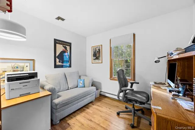 Bedroom or versatile home office featuring hardwood flooring, recessed ceiling lighting, and ample natural light Bedroom or versatile home office featuring hardwood flooring, recessed ceiling lighting, and ample natural light