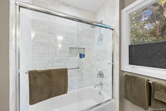 Tub-shower combination featuring subway tile surround, glass sliding door, and integrated shower niche Tub-shower combination featuring subway tile surround, glass sliding door, and integrated shower niche