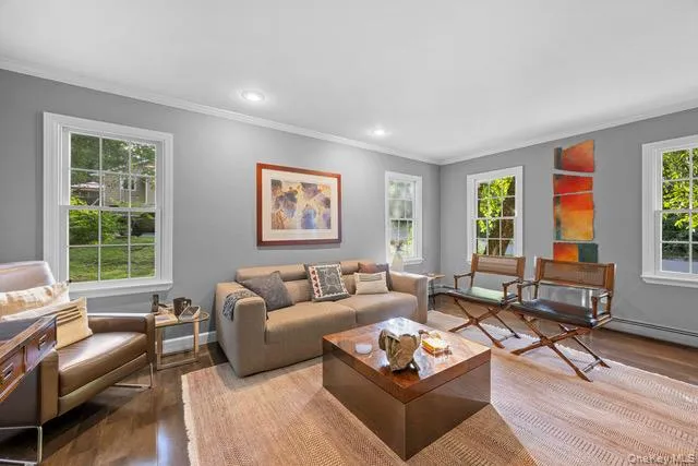 Wood flooring, recessed lighting, crown molding, and multiple windows with white trim Wood flooring, recessed lighting, crown molding, and multiple windows with white trim