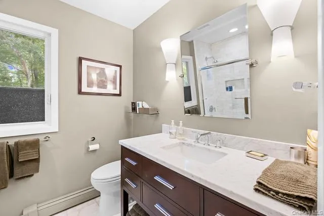 Second full bath. Single vanity with a white countertop and integrated sink, dark wood-finish cabinetry, and chrome fixtures. Second full bath. Single vanity with a white countertop and integrated sink, dark wood-finish cabinetry, and chrome fixtures.