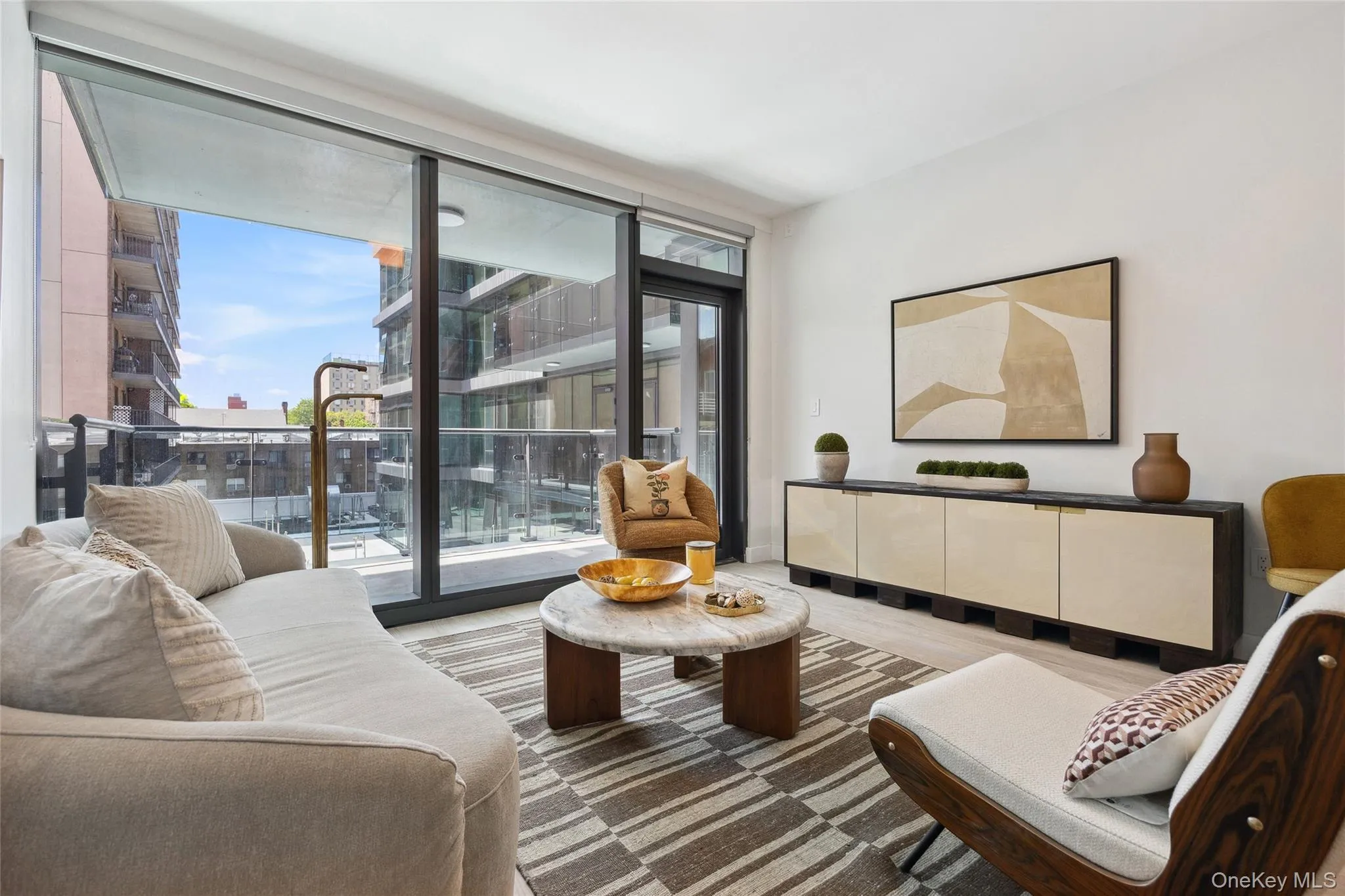 Living area with healthy amount of natural light, a wall of windows, and wood finished floors Living area with healthy amount of natural light, a wall of windows, and wood finished floors