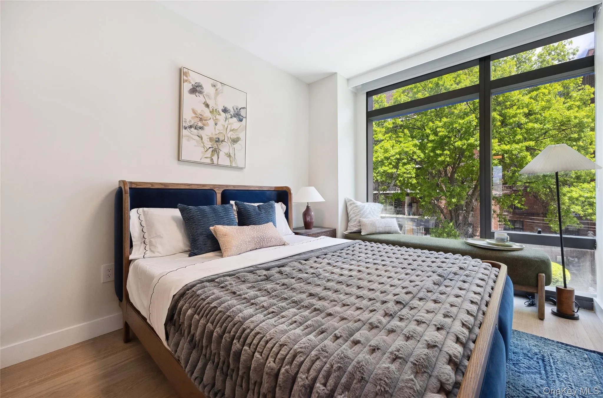Bedroom with multiple windows, baseboards, wood finished floors, and expansive windows Bedroom with multiple windows, baseboards, wood finished floors, and expansive windows