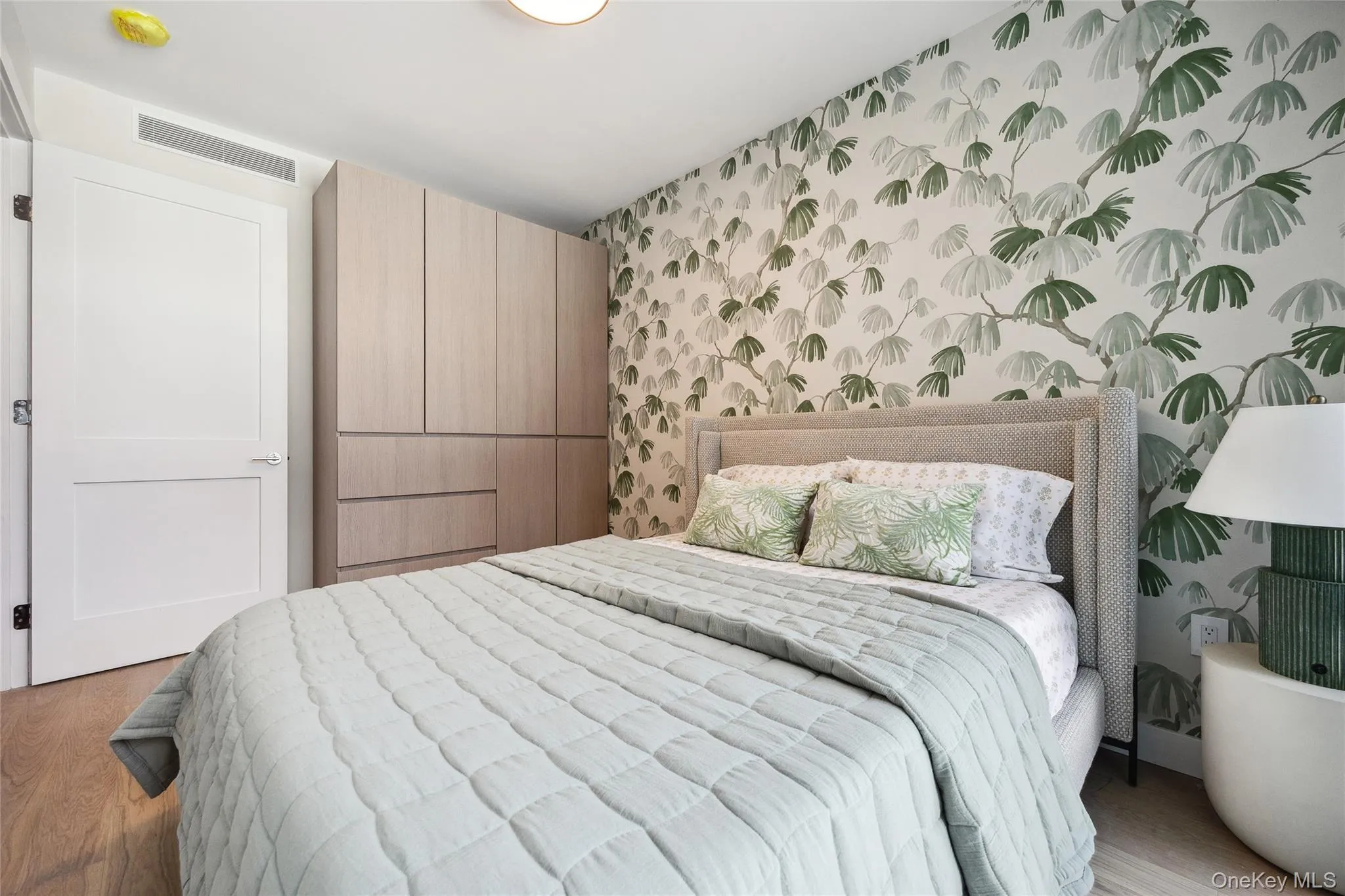Bedroom with wallpapered walls and wood finished floors Bedroom with wallpapered walls and wood finished floors
