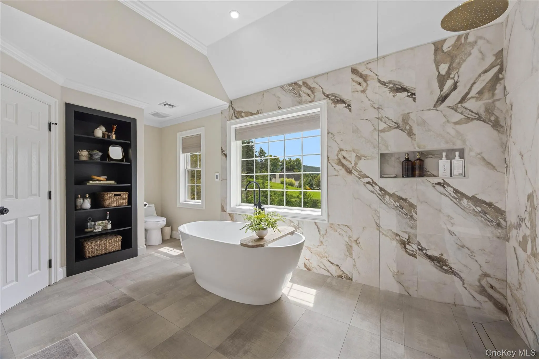 Full bathroom featuring crown molding, a freestanding bath, built in features, a marble finish shower, and recessed lighting Full bathroom featuring crown molding, a freestanding bath, built in features, a marble finish shower, and recessed lighting