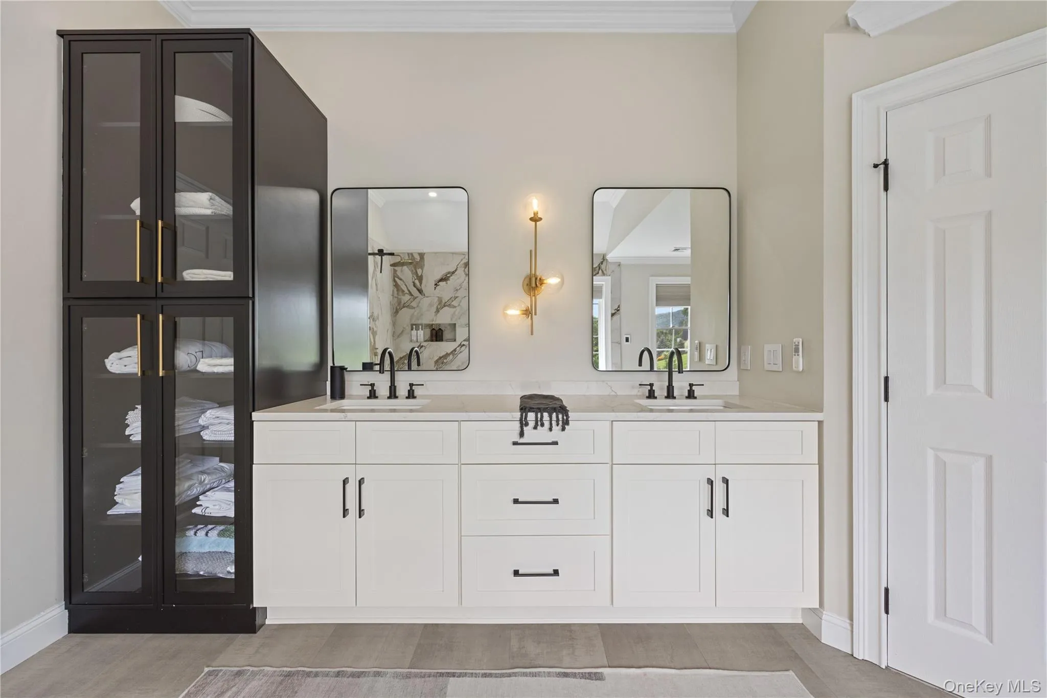 Bathroom featuring double vanity, ornamental molding, and light wood-style floors Bathroom featuring double vanity, ornamental molding, and light wood-style floors