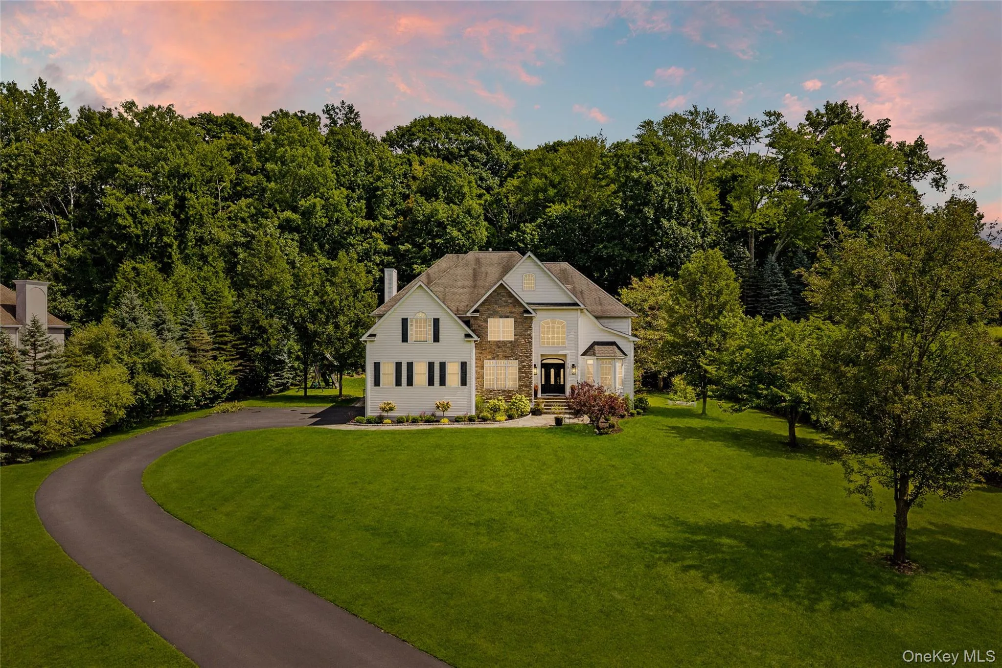 View of front of house featuring a front lawn, stone siding, and a chimney View of front of house featuring a front lawn, stone siding, and a chimney