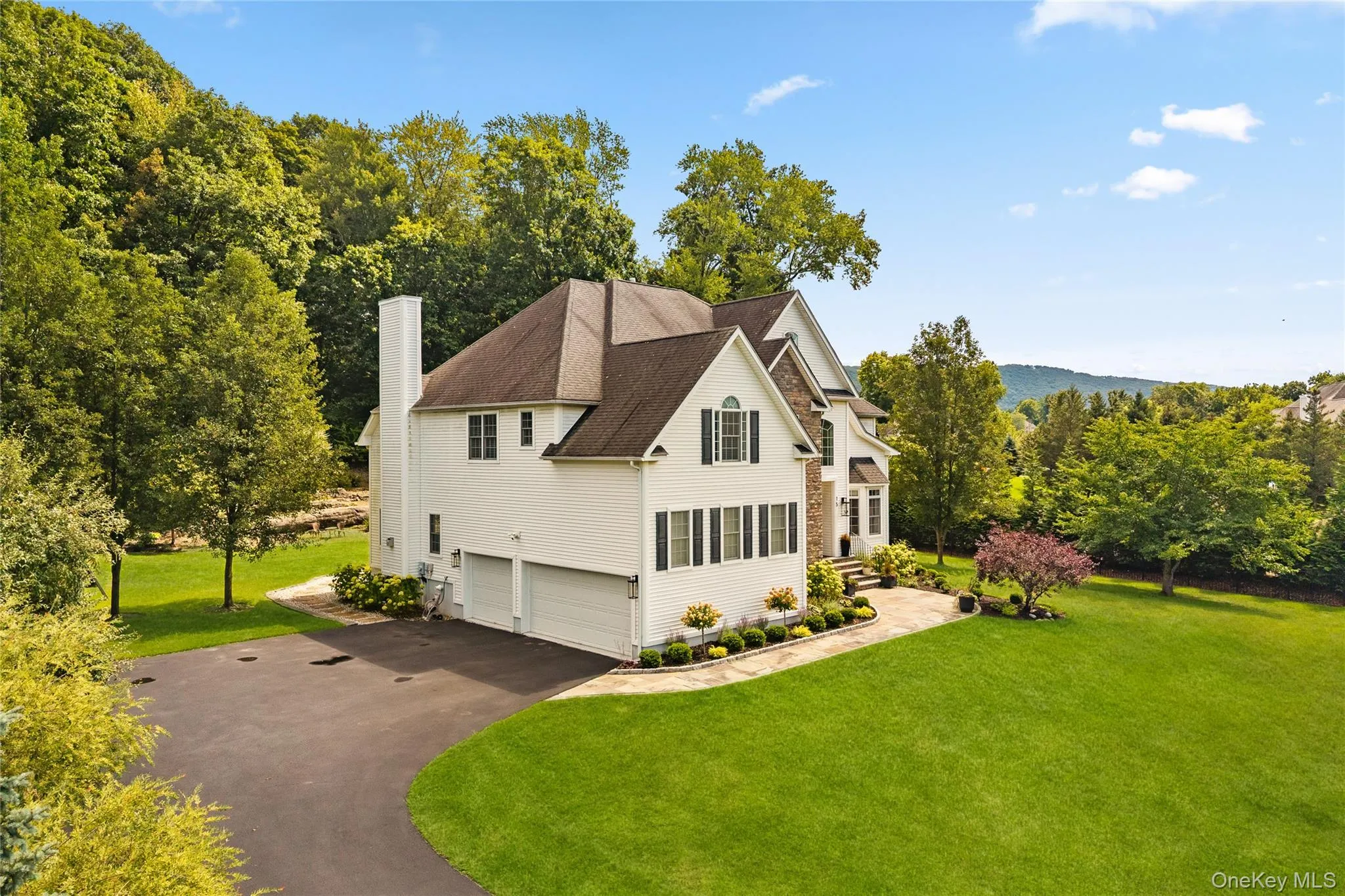 View of property exterior with a lawn, a garage, asphalt driveway, a chimney, and roof with shingles View of property exterior with a lawn, a garage, asphalt driveway, a chimney, and roof with shingles