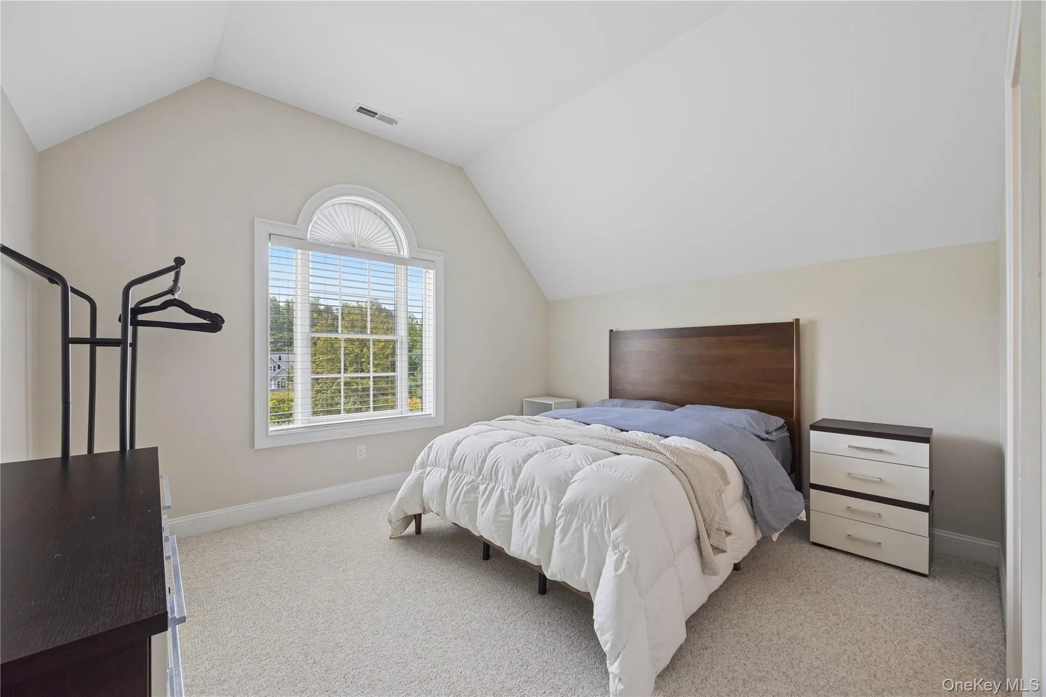 Bedroom featuring vaulted ceiling and light carpet Bedroom featuring vaulted ceiling and light carpet