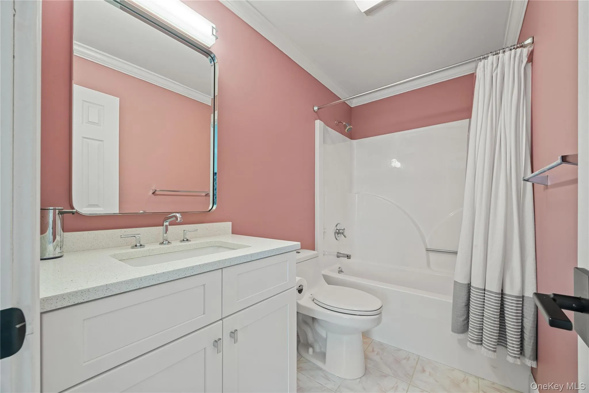 Full bathroom featuring shower / bathtub combination with curtain, vanity, and ornamental molding Full bathroom featuring shower / bathtub combination with curtain, vanity, and ornamental molding