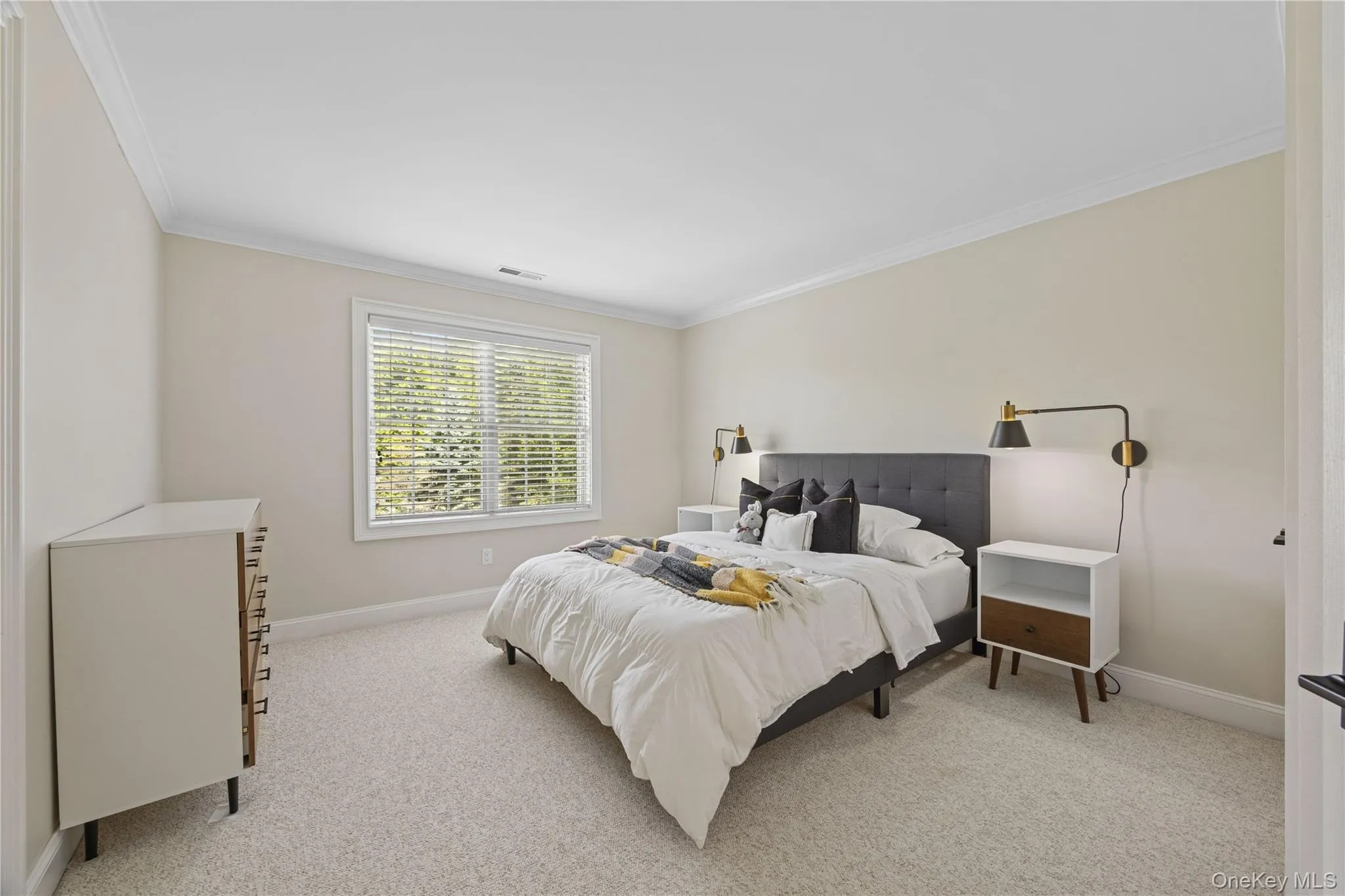 Bedroom with ornamental molding and light colored carpet Bedroom with ornamental molding and light colored carpet