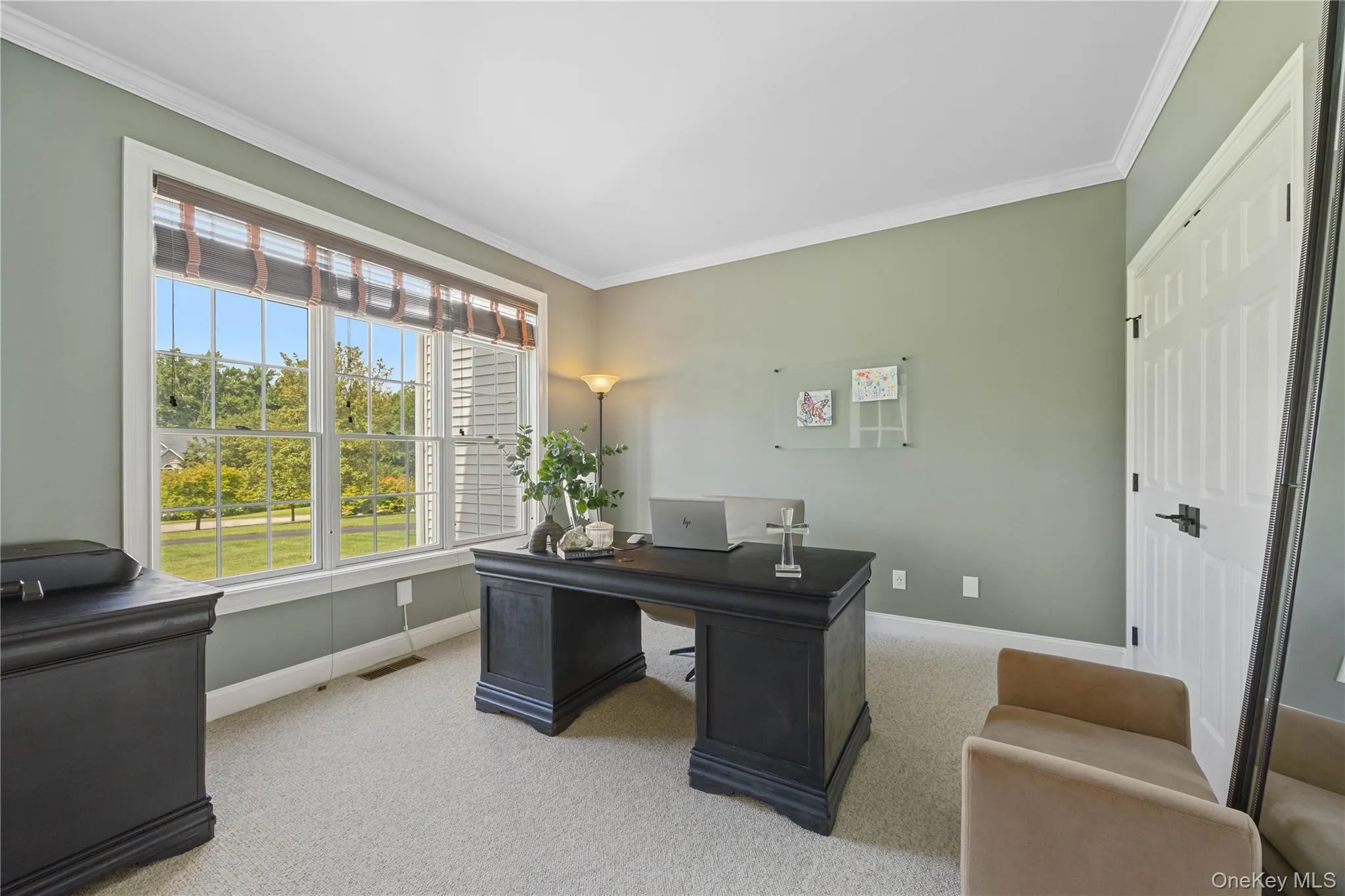 Home office featuring ornamental molding and light colored carpet Home office featuring ornamental molding and light colored carpet