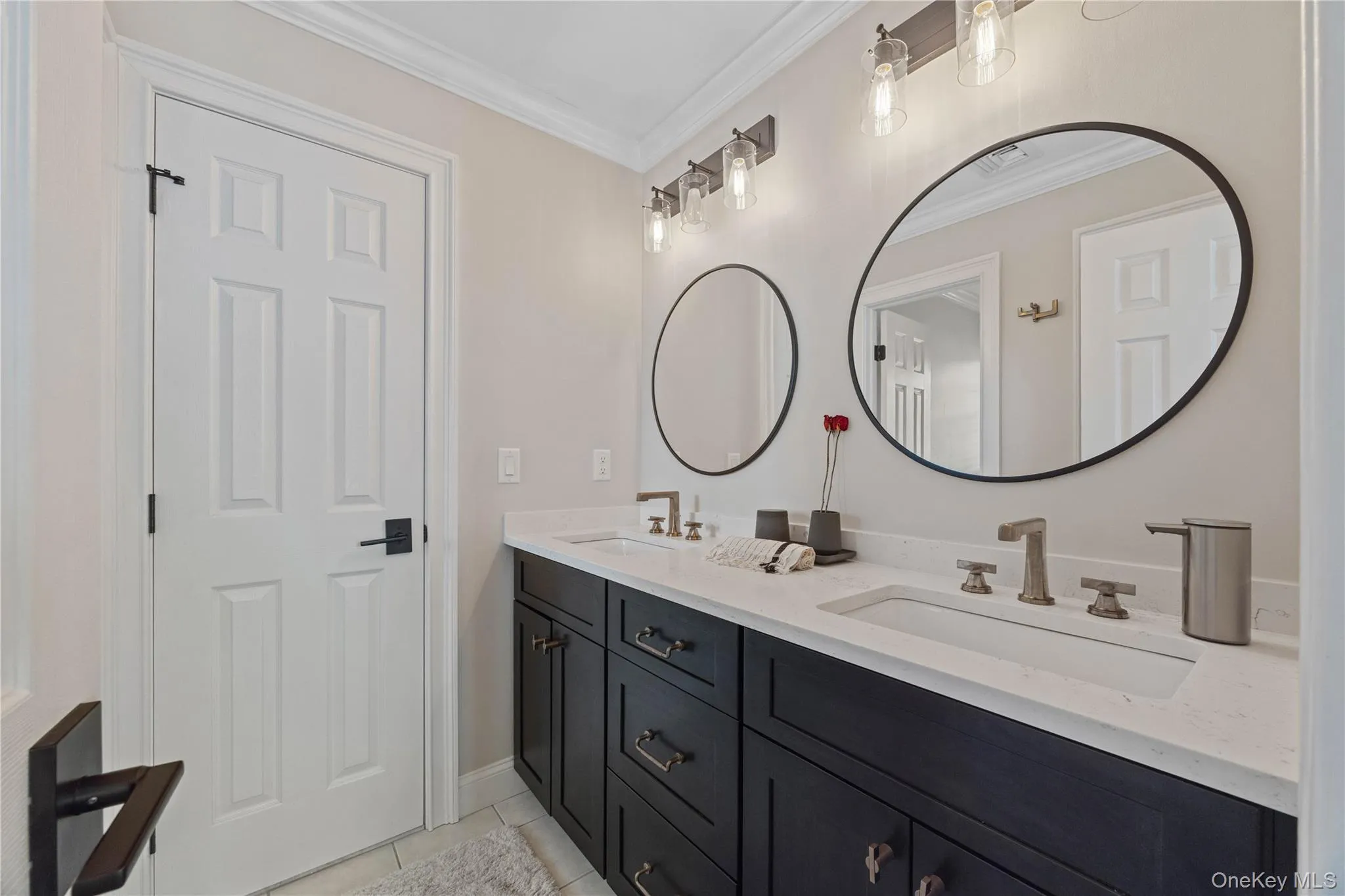 Full bathroom with double vanity, light tile patterned floors, and ornamental molding Full bathroom with double vanity, light tile patterned floors, and ornamental molding