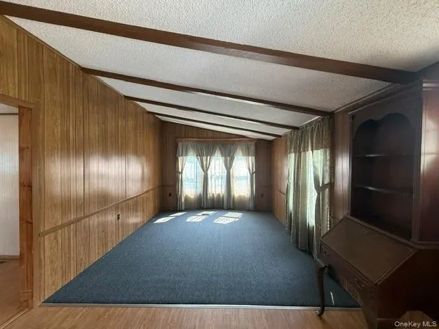 wood paneling, carpet and beams wood paneling, carpet and beams