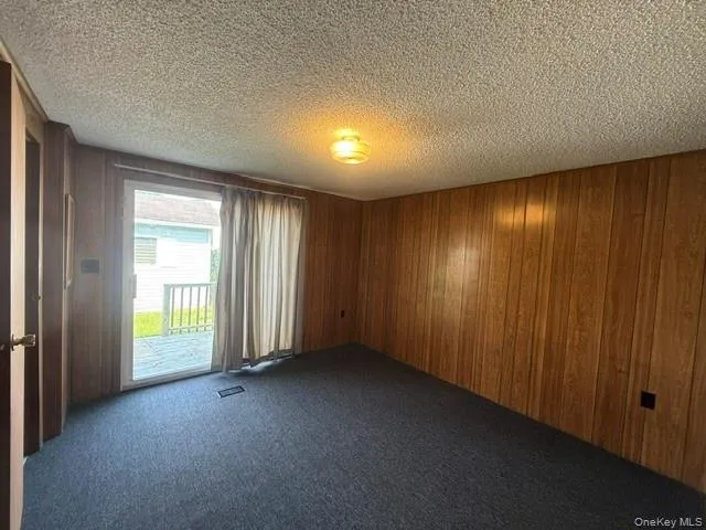 wood paneling, sliding glass doors to porch, carpeted and walk-in closet wood paneling, sliding glass doors to porch, carpeted and walk-in closet