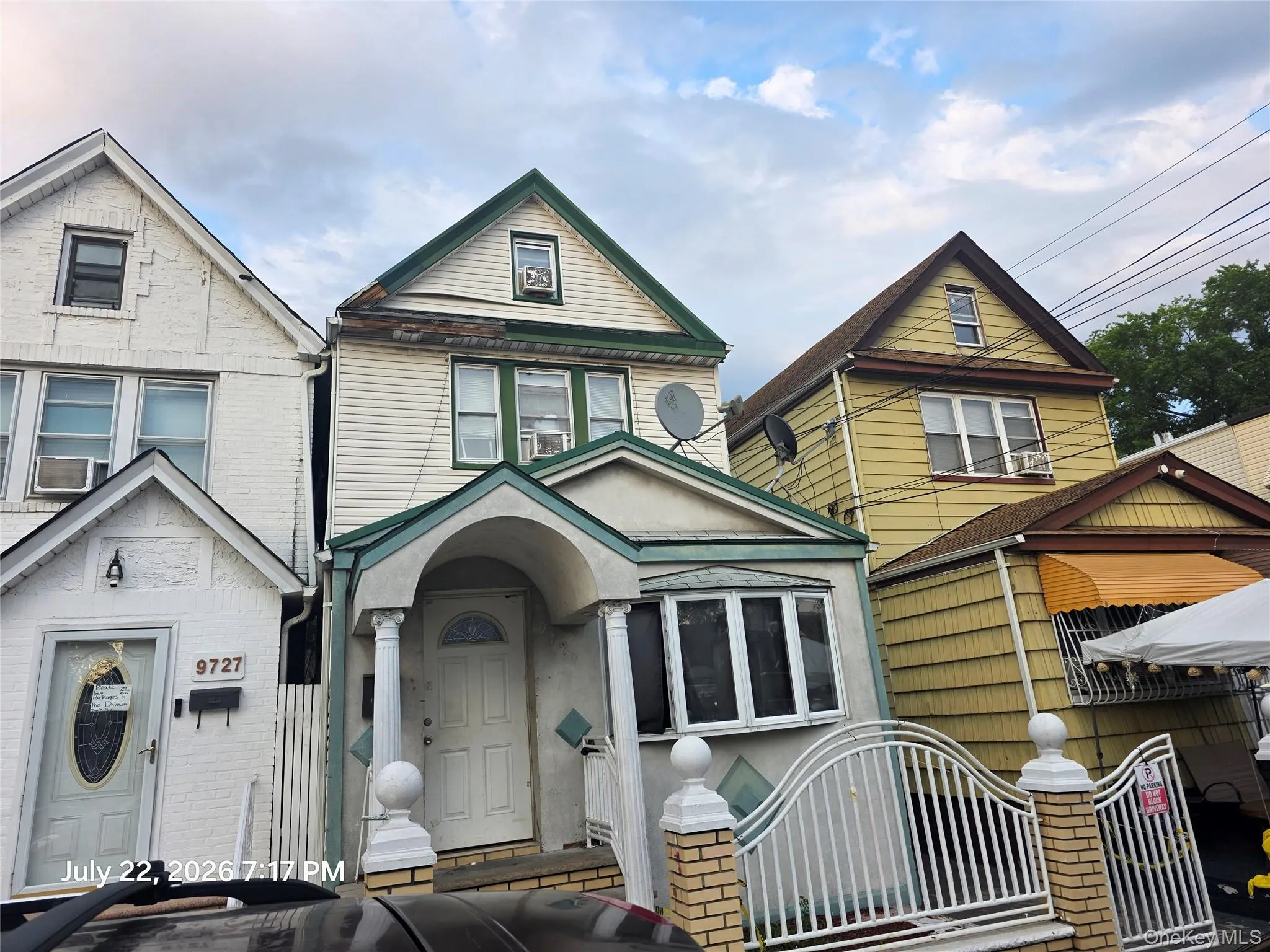 Charming two-story residence featuring a welcoming arched entryway with decorative columns, multi-pane windows, and neutral siding exterior Charming two-story residence featuring a welcoming arched entryway with decorative columns, multi-pane windows, and neutral siding exterior