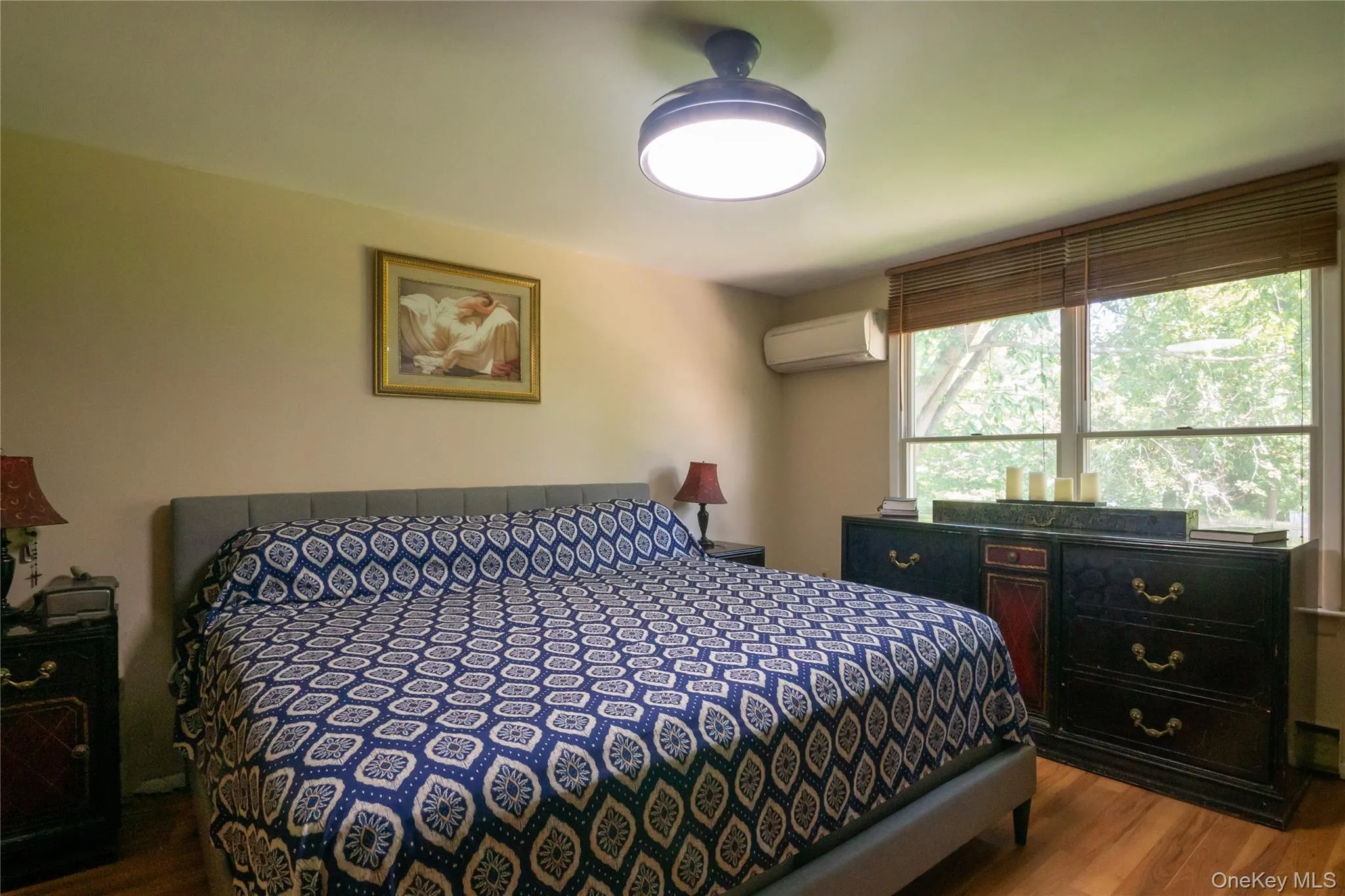 Primary bedroom with multiple windows offering natural light and views of the surrounding greenery. Primary bedroom with multiple windows offering natural light and views of the surrounding greenery.