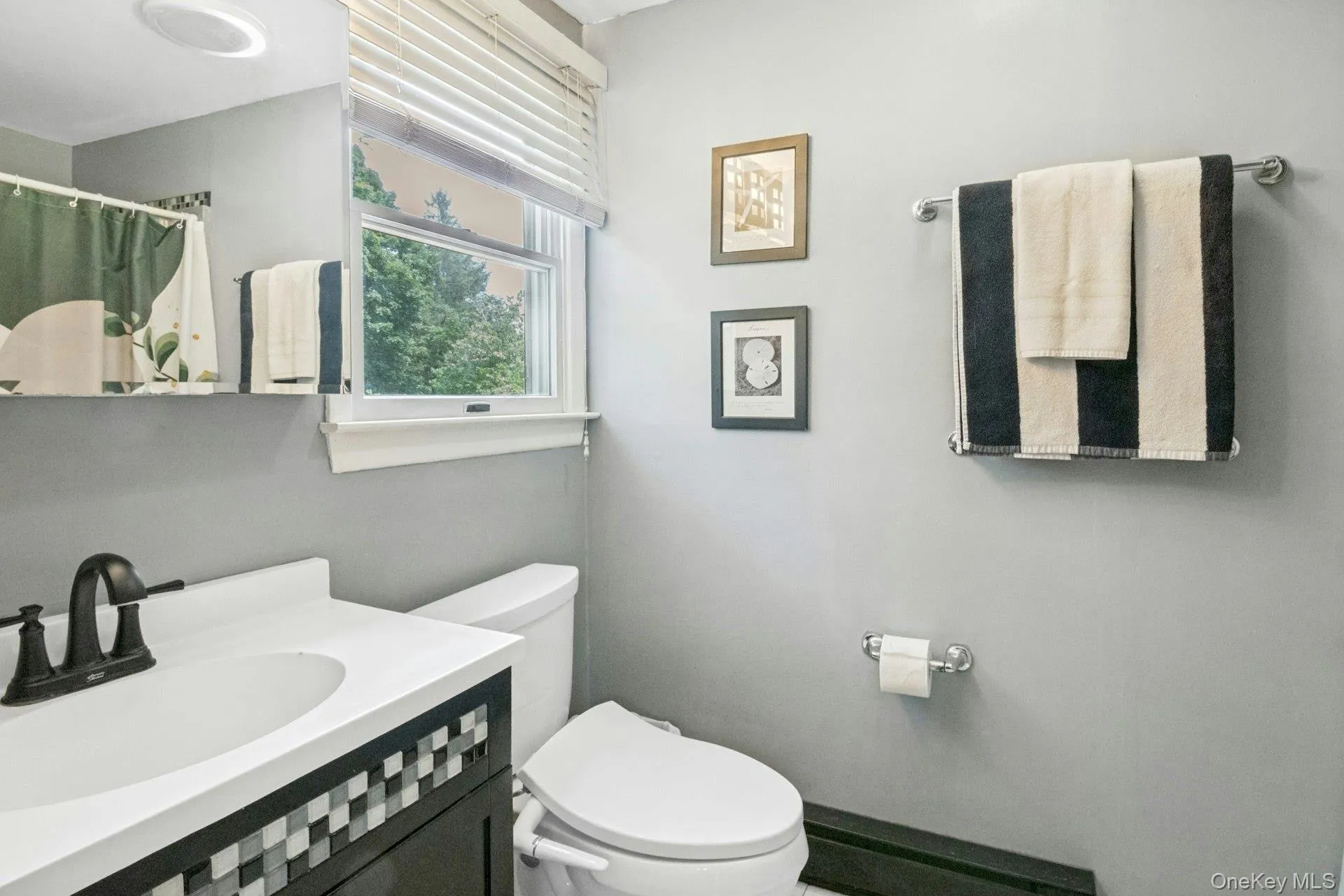 Primary en-suite bathroom with tile flooring, vanity, wall mirror, and walk-in shower Primary en-suite bathroom with tile flooring, vanity, wall mirror, and walk-in shower