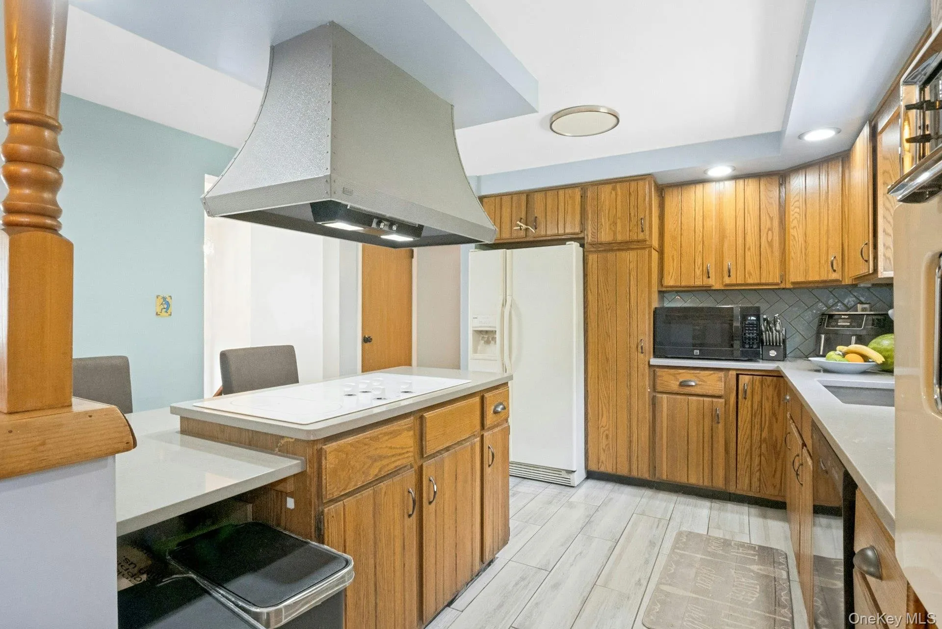 Eat-in kitchen with oak cabinetry, Corian countertops, center island cooktop, and ample workspace. Eat-in kitchen with oak cabinetry, Corian countertops, center island cooktop, and ample workspace.