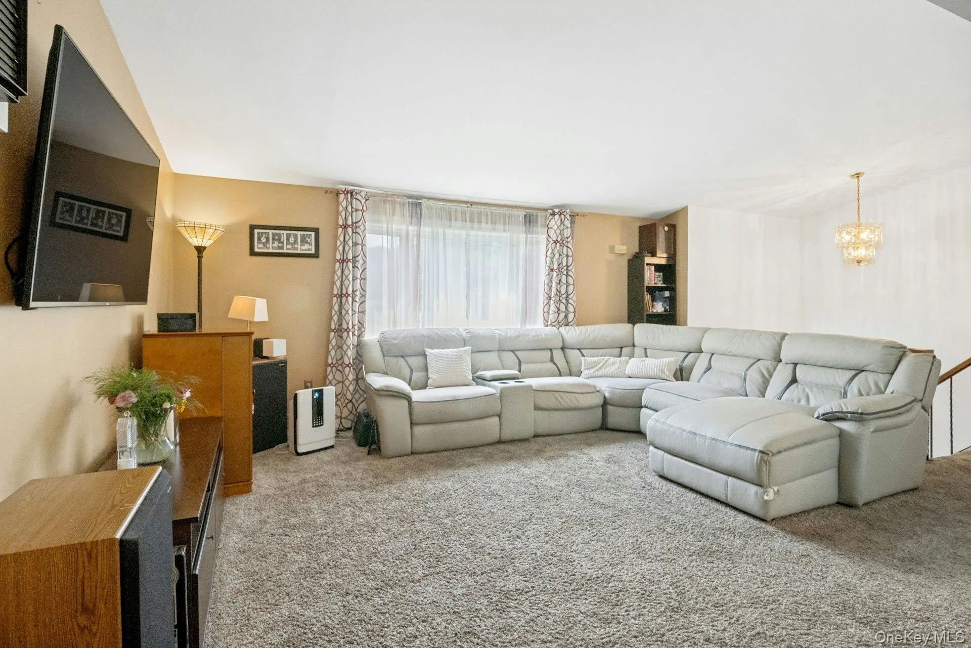 Spacious living room with large front-facing windows and plenty of room for multiple seating arrangements. Spacious living room with large front-facing windows and plenty of room for multiple seating arrangements.
