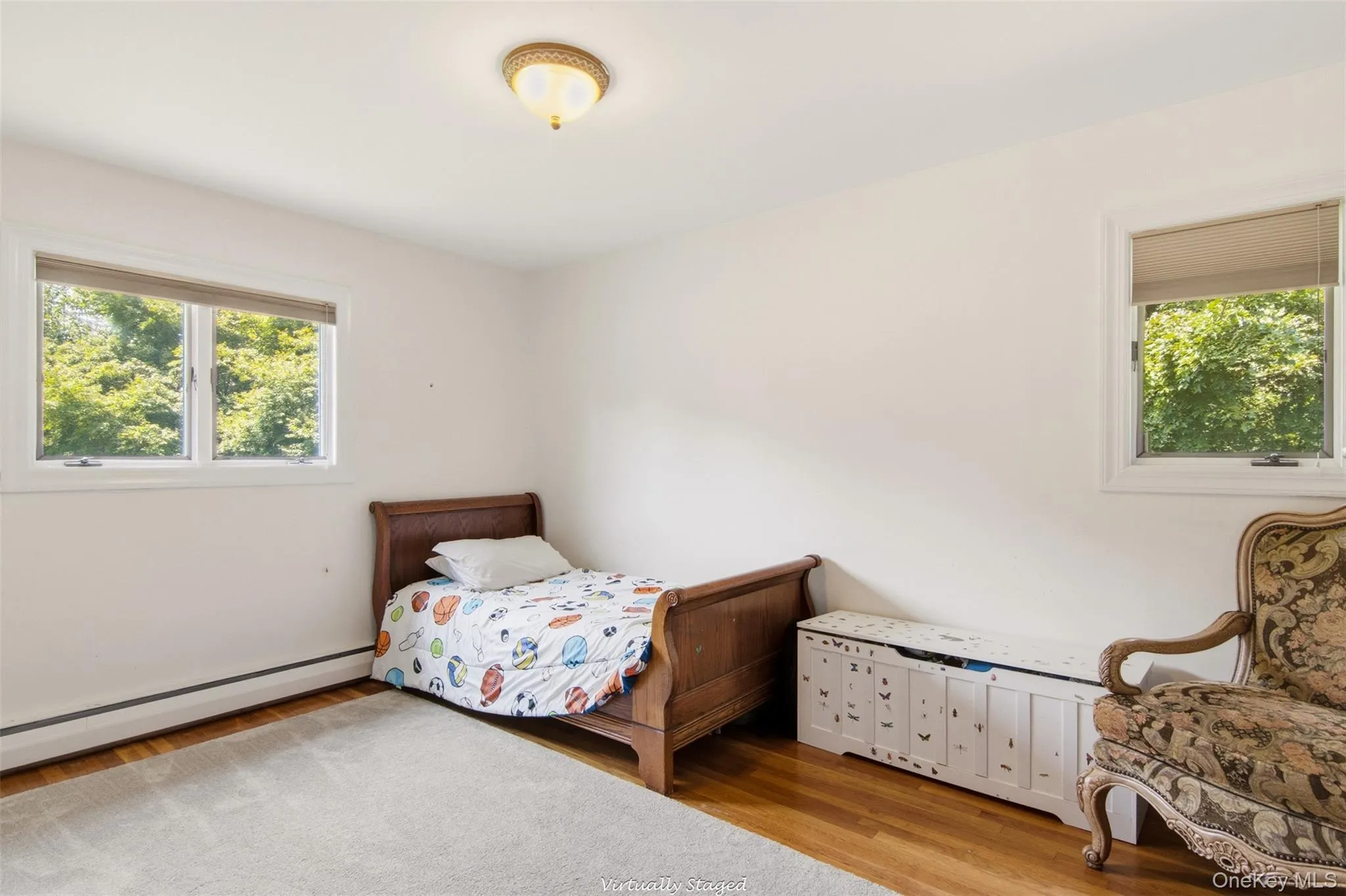 Natural light from multiple windows, wood-finish flooring, and a flush mount ceiling light fixture Natural light from multiple windows, wood-finish flooring, and a flush mount ceiling light fixture
