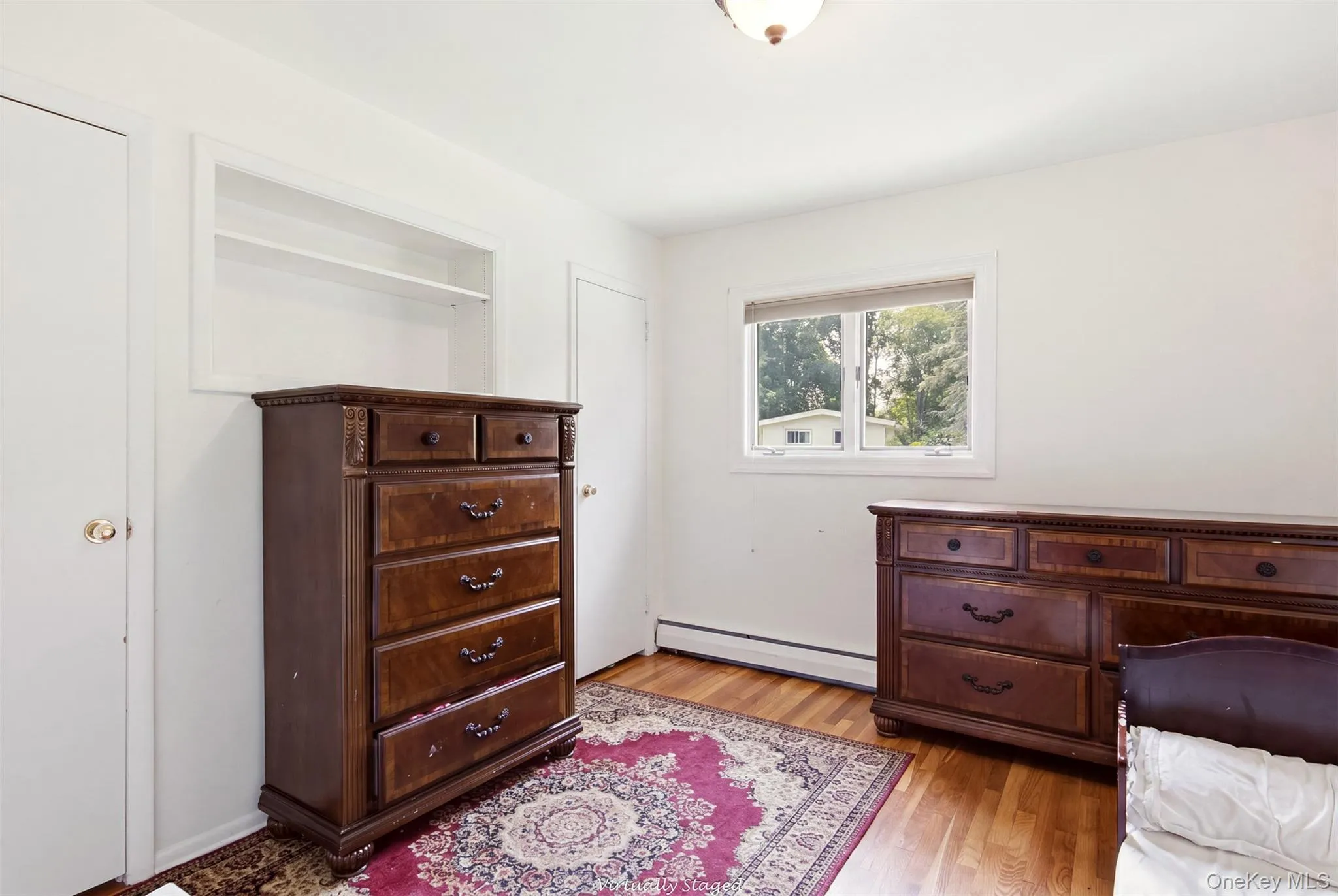 Hardwood flooring, built-in shelving, white trim, and a double-hung window Hardwood flooring, built-in shelving, white trim, and a double-hung window