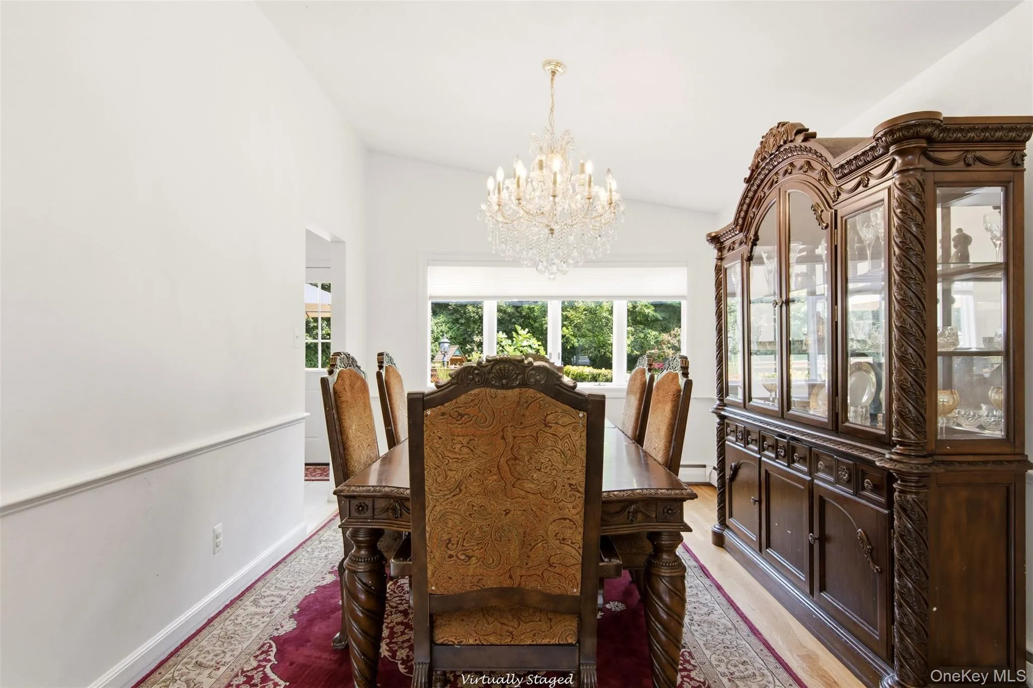 Vaulted ceiling with a crystal chandelier, bay window, and wood-finish flooring Vaulted ceiling with a crystal chandelier, bay window, and wood-finish flooring