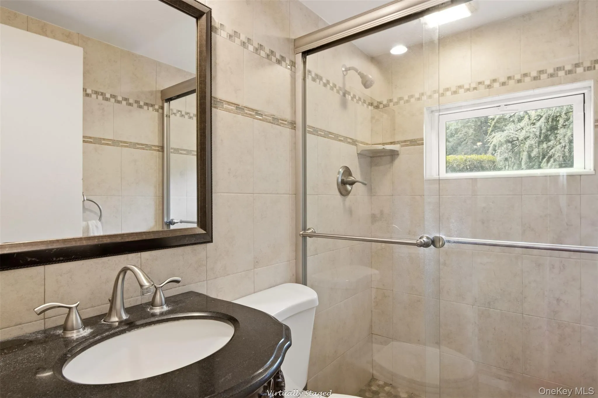 Glass-enclosed shower with pebble-finish flooring Glass-enclosed shower with pebble-finish flooring