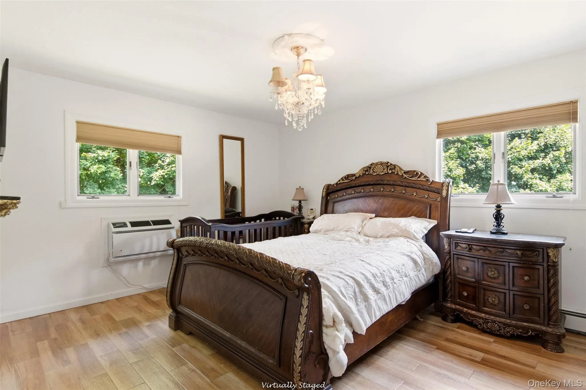 Hardwood-style flooring, white walls, two large windows, and a decorative chandelier Hardwood-style flooring, white walls, two large windows, and a decorative chandelier