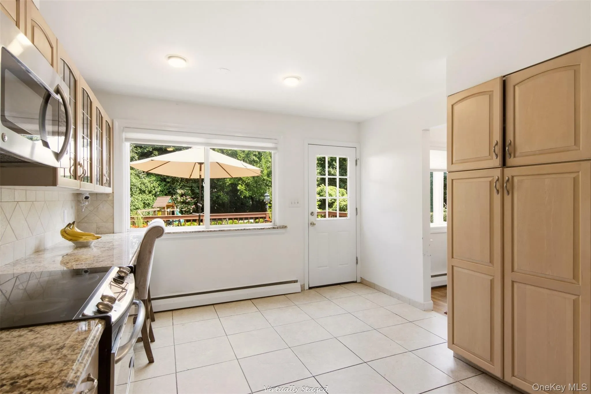 Kitchen featuring light wood-finish cabinetry, tile flooring, and granite-look countertops Kitchen featuring light wood-finish cabinetry, tile flooring, and granite-look countertops