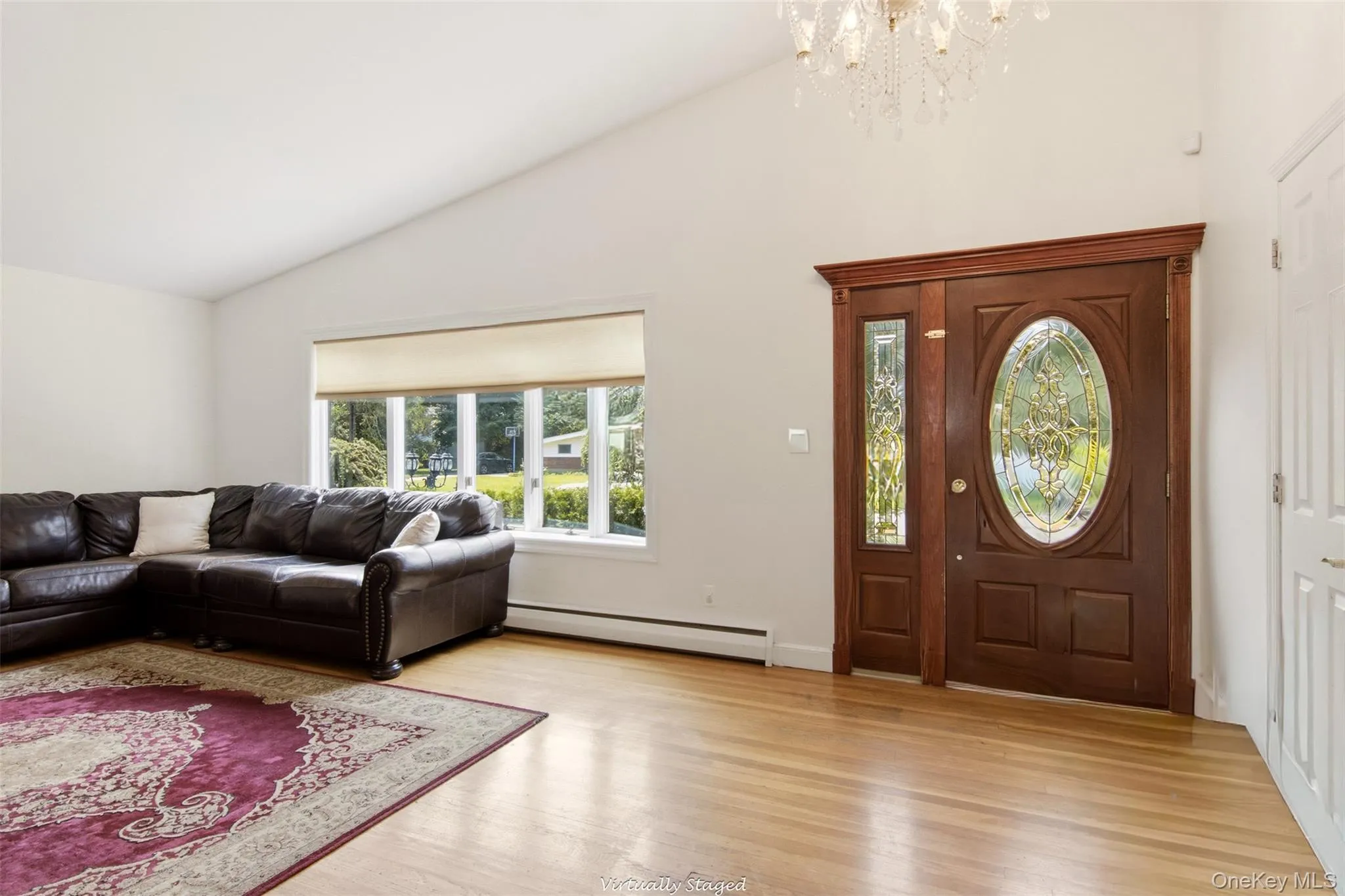 Hardwood flooring, vaulted ceiling, large picture window, and an ornate front door with sidelight Hardwood flooring, vaulted ceiling, large picture window, and an ornate front door with sidelight