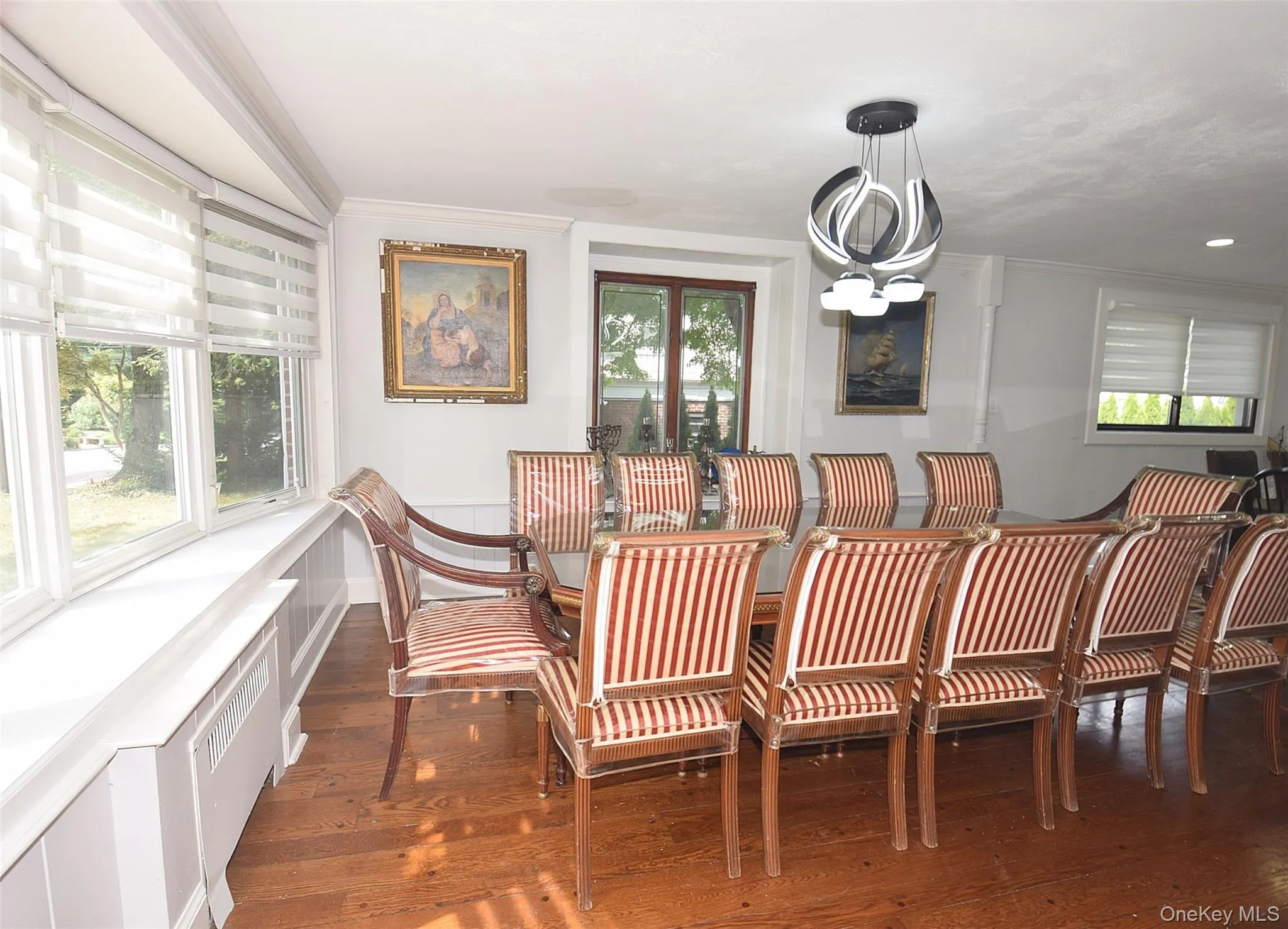 Hardwood flooring, bay window with integrated window treatment, modern ceiling fixture, and crown molding Hardwood flooring, bay window with integrated window treatment, modern ceiling fixture, and crown molding