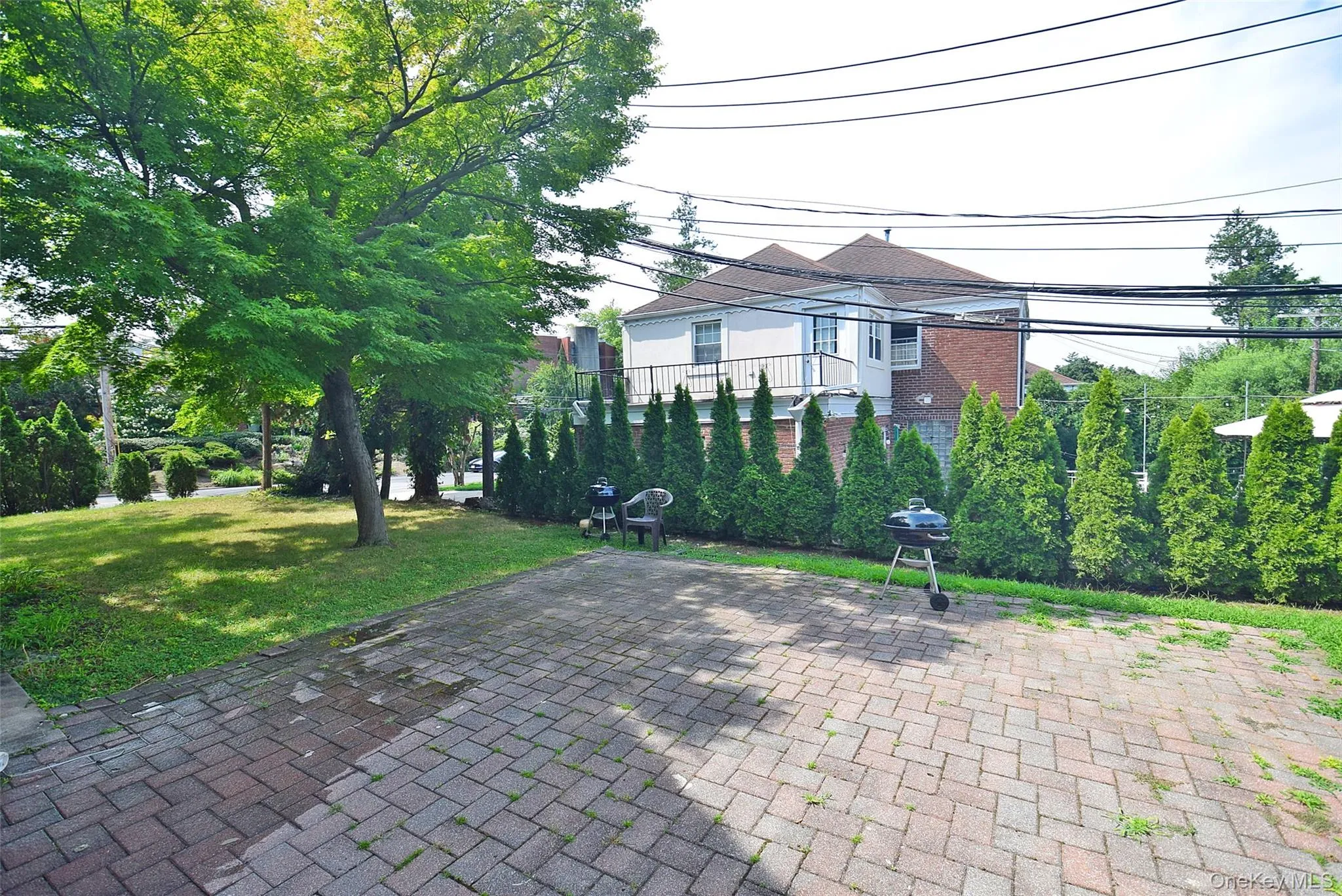 Paved patio area, manicured lawn, mature trees, and privacy hedging Paved patio area, manicured lawn, mature trees, and privacy hedging