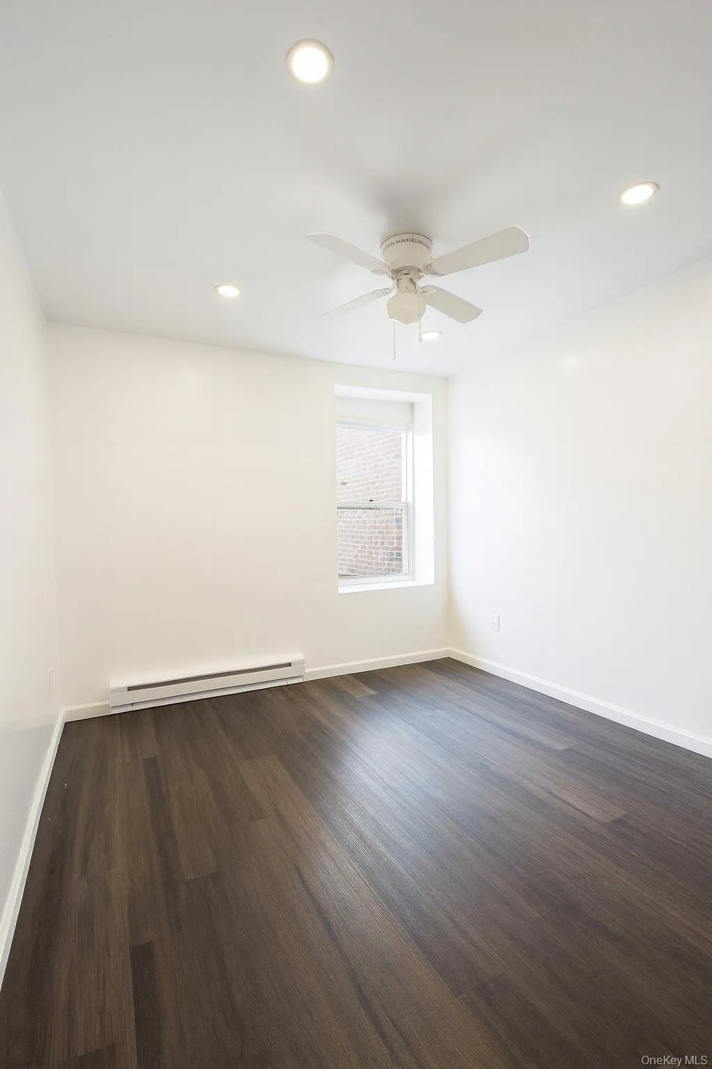 Spare room with dark wood-style flooring, recessed lighting, baseboard heating, and a ceiling fan Spare room with dark wood-style flooring, recessed lighting, baseboard heating, and a ceiling fan