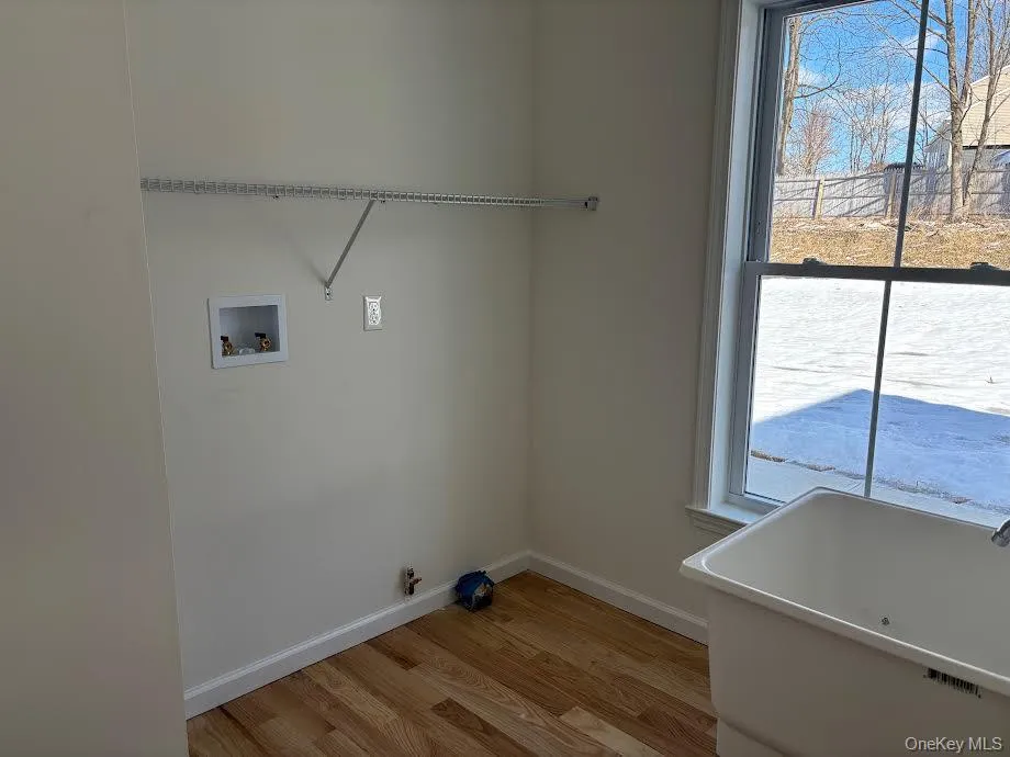 Laundry area with hookup for a washing machine, hookup for a gas dryer, and hardwood / wood-style floors Laundry area with hookup for a washing machine, hookup for a gas dryer, and hardwood / wood-style floors