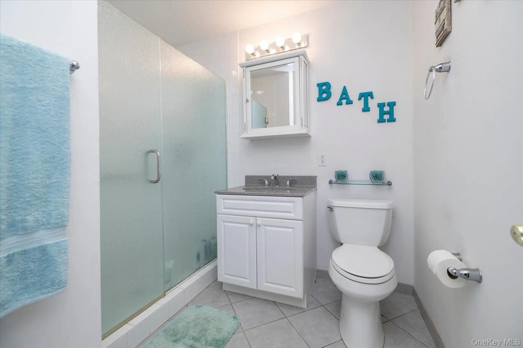White vanity with a stone countertop and chrome fixtures White vanity with a stone countertop and chrome fixtures