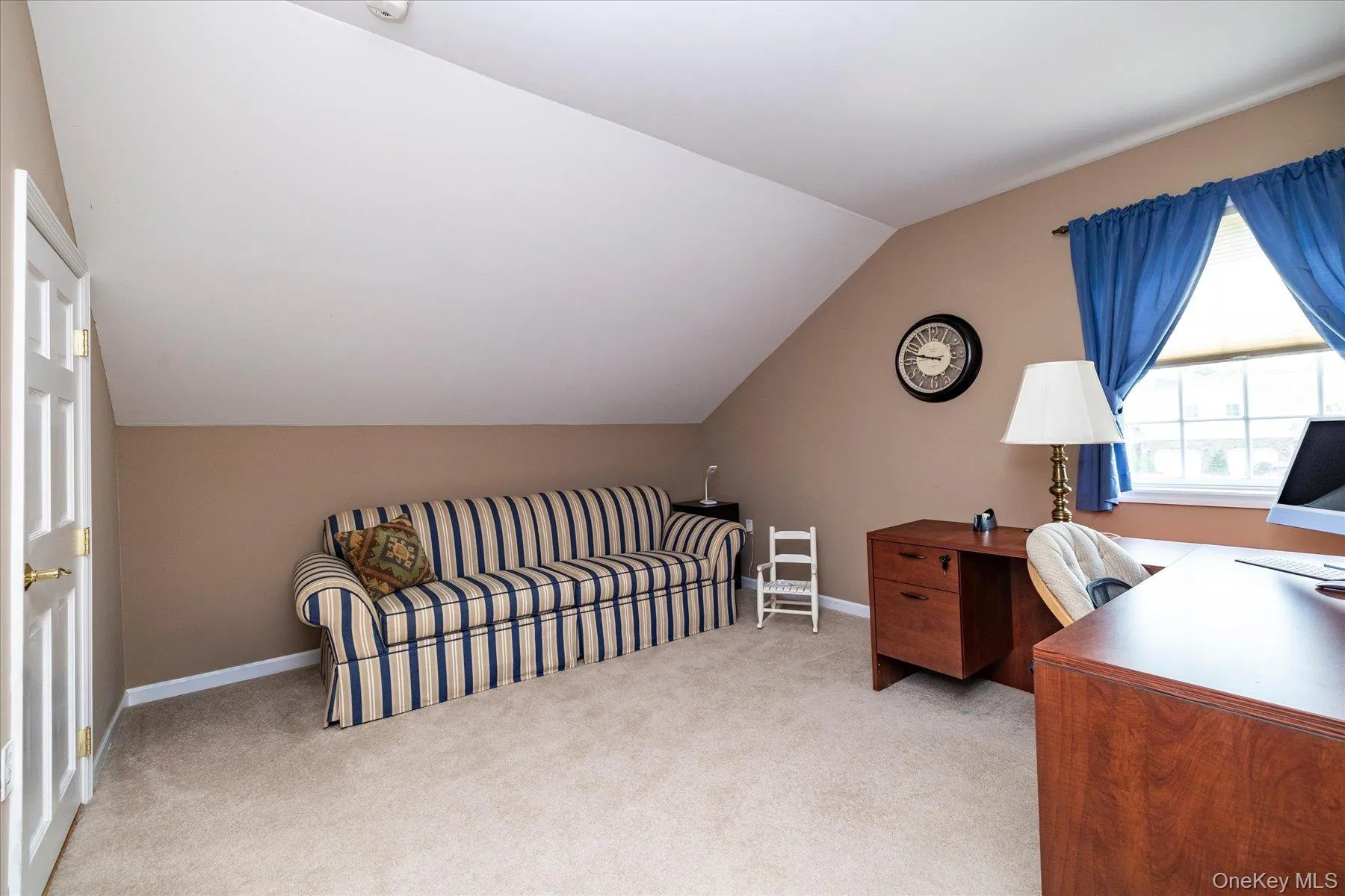 Carpeted room with a pitched ceiling and a window featuring natural light and walk-in closet Carpeted room with a pitched ceiling and a window featuring natural light and walk-in closet