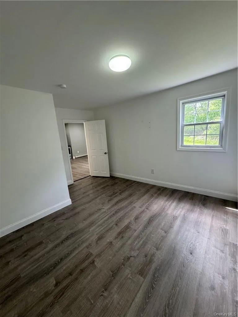 Spare room featuring dark hardwood / wood-style floors Spare room featuring dark hardwood / wood-style floors