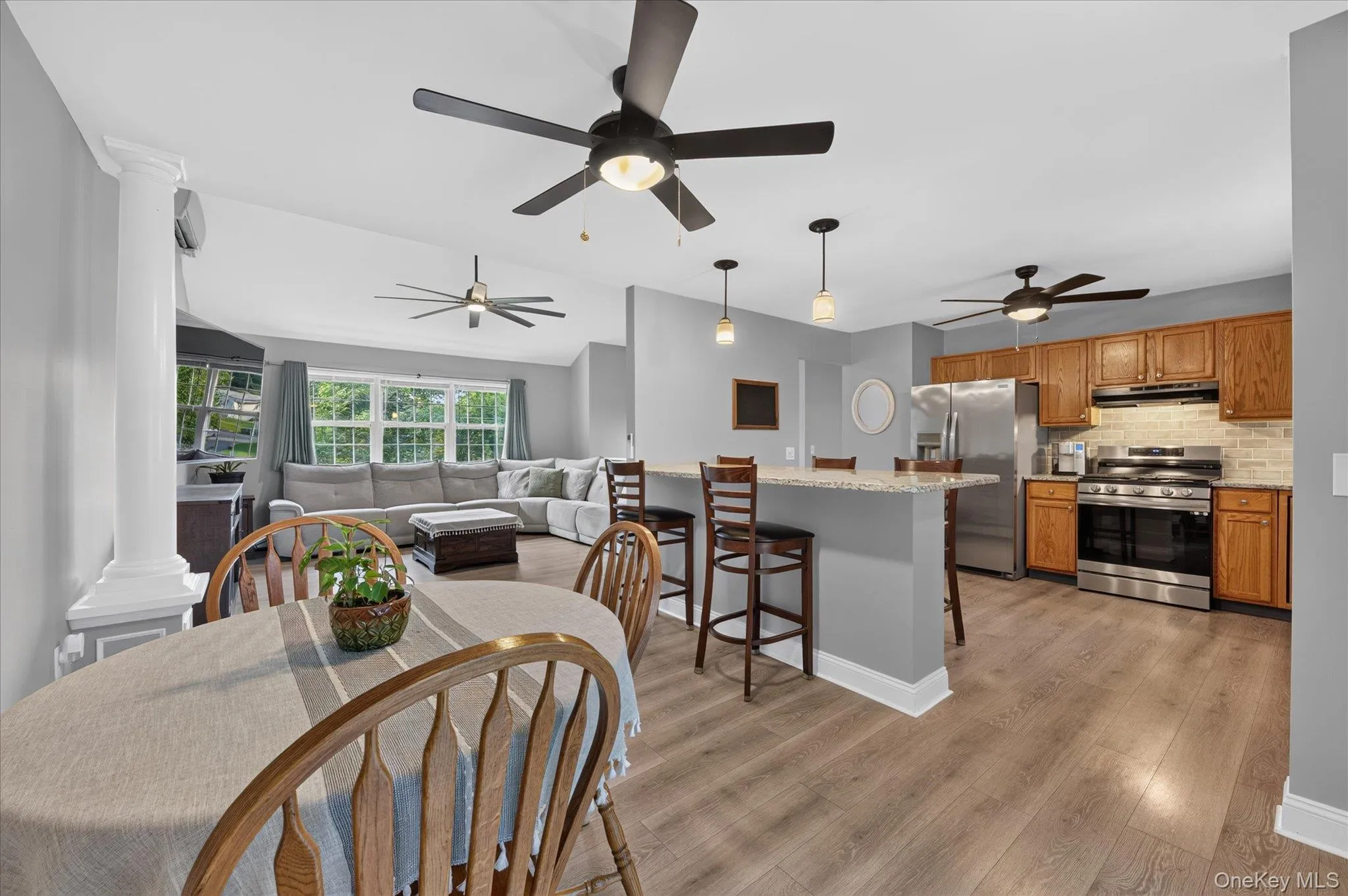 Open-concept living space featuring wood-finish flooring, recessed lighting, and multiple ceiling fans Open-concept living space featuring wood-finish flooring, recessed lighting, and multiple ceiling fans